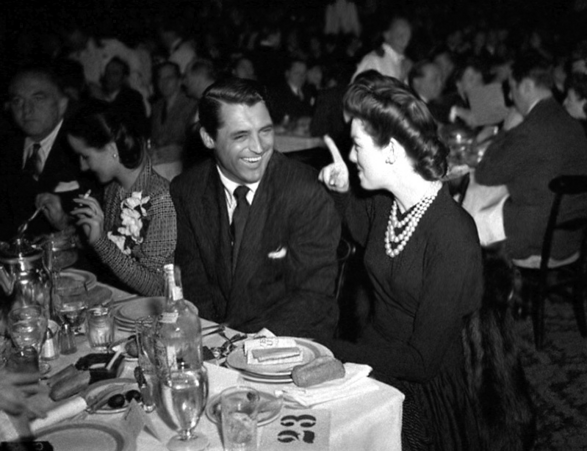 Cary Grant en tafelgenote tijdens een diner ter gelegenheid van de Oscars-uitreiking.